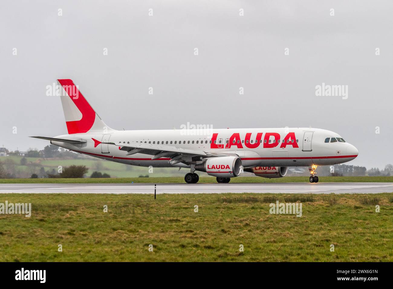 Lauda Air Airbus A320-214 fährt auf der Landebahn am Flughafen Cork, Cork, Irland. Stockfoto
