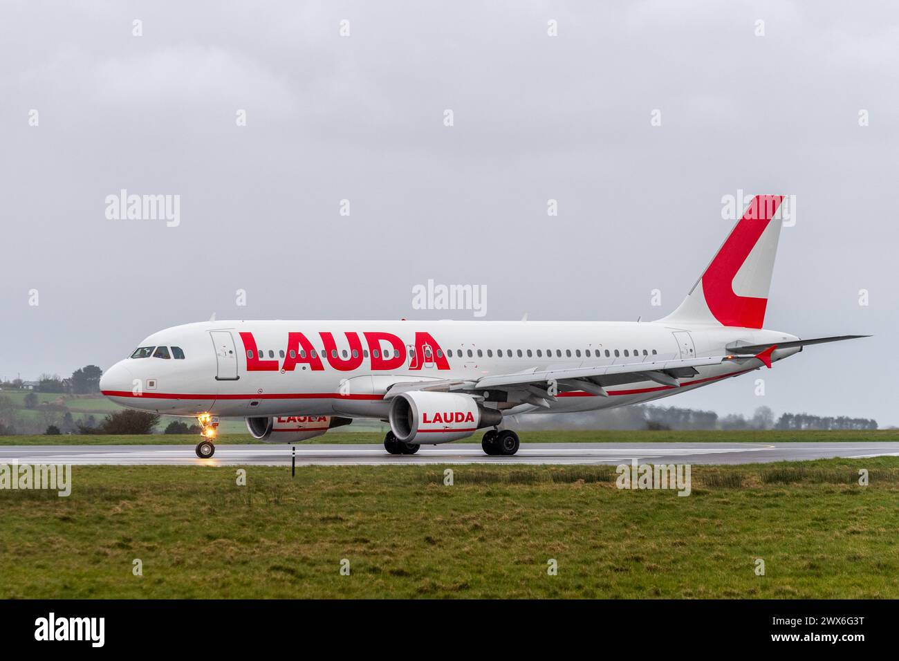 Lauda Air Airbus A320-214 fährt auf der Landebahn am Flughafen Cork, Cork, Irland. Stockfoto