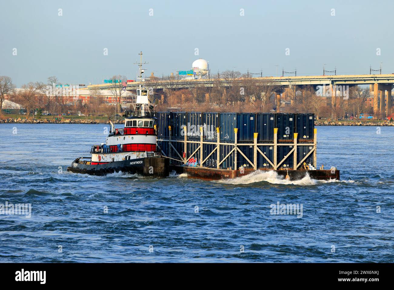 Der Schlepper Pathfinder, in abgehackten Gewässern in der Nähe von Hell Gate im East River, mit einem Lastkahn mit Schiffscontainern, die NYC-Müll enthalten, in New York City. Stockfoto