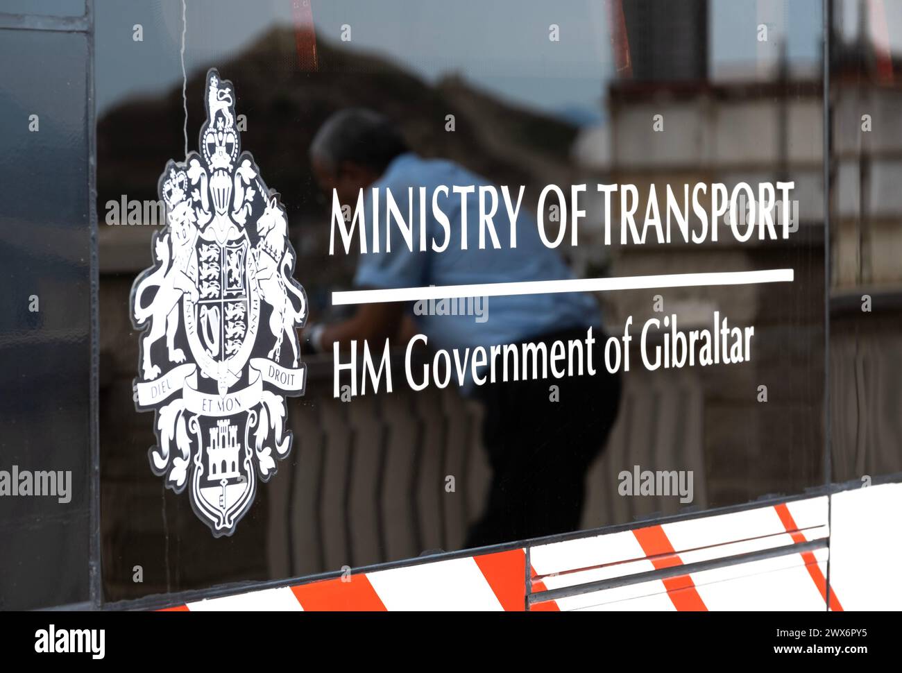 Seitenfenster in einem Bus in Gibraltar mit dem Wappen der Regierung von Gibraltar und dem Schild des Verkehrsministeriums auf dem Glas. Stockfoto