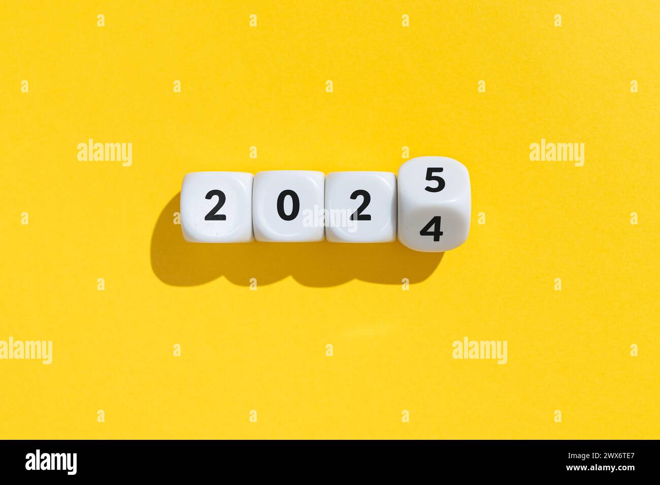 Neujahr von 2024 bis 2025 Konzept. Text auf Cube-Blöcken isoliert auf gelbem Hintergrund Stockfoto