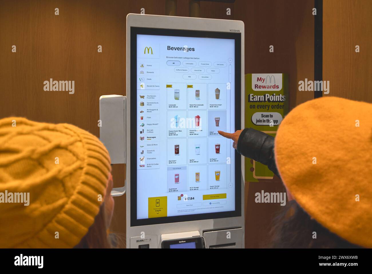 Nueva York, USA – 28. März 2024: McDonald's, bei dem zwei weibliche Kunden mit einem Selbstbedienungskiosk interagieren. Stockfoto