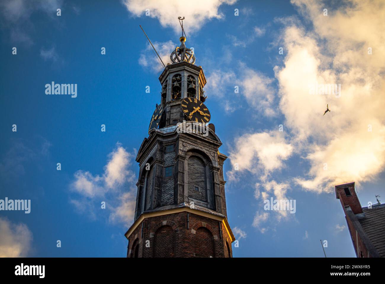 Steigen Sie auf den Gipfel einer alten Kirche in Amsterdam, um einen Panoramablick zu genießen, wo historische Türme den Himmel in dieser ikonischen europäischen Stadtlandschaft berühren. Stockfoto