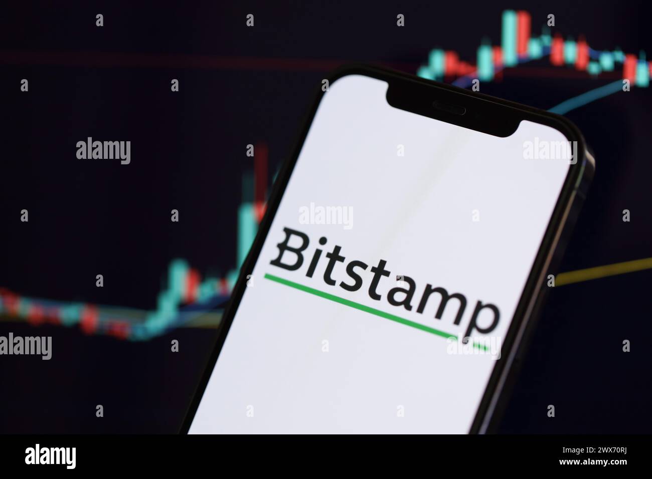 KIEW, UKRAINE - 15. MÄRZ 2024 Bitstamp-Logo auf iPhone-Display und Kryptowährungswertdiagramme. Portal für den Austausch von Kryptowährungen Stockfoto