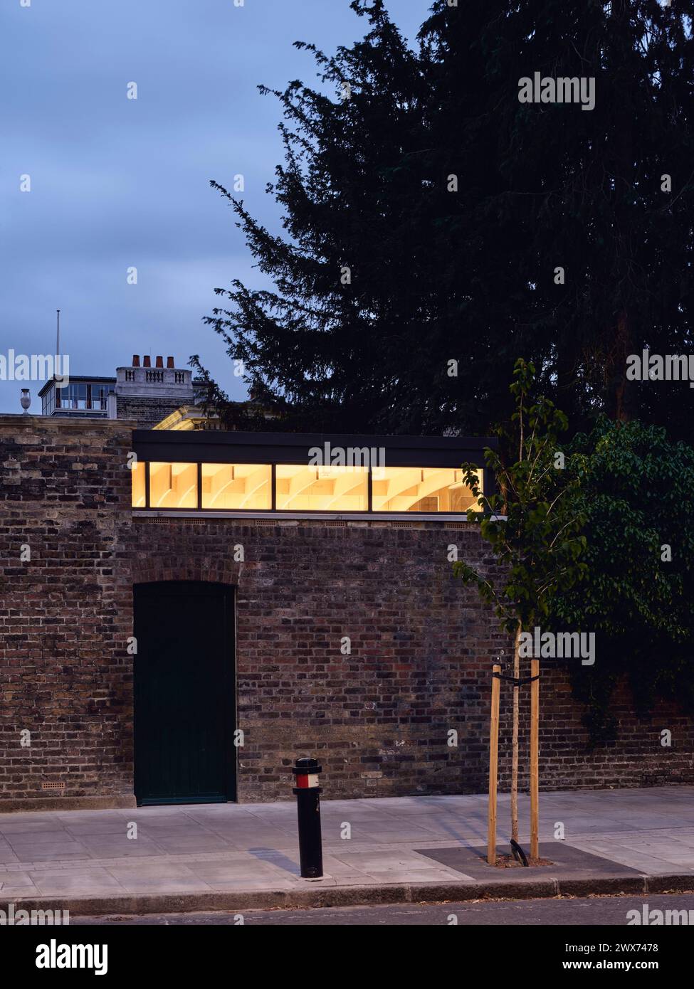 Seitlicher Eingang zum Hub in der Abenddämmerung. Pitzhanger Hub, London, Großbritannien. Architekt: Jo Townshend, 2023. Stockfoto