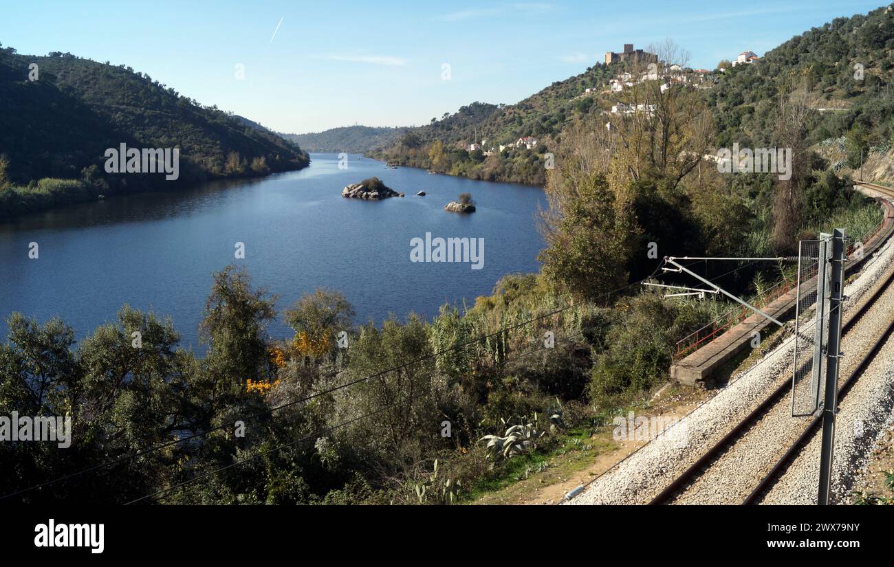 Fluss Tejo, mit der Eisenbahn am rechten Ufer, auf einem Hügel gelegene mittelalterliche Burg von Belver mit Blick auf die Landschaft im Hintergrund, Belver, Portugal Stockfoto