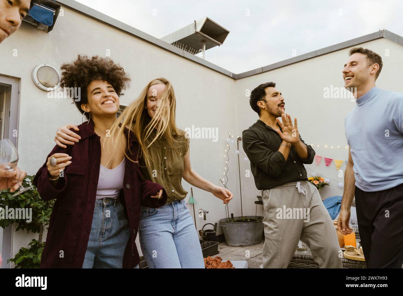 Gruppe männlicher und weiblicher Freunde, die auf einer Party auf dem Balkon tanzen Stockfoto