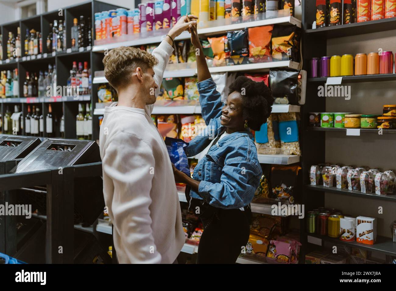 Romantisches, multirassisches Paar tanzen beim Einkaufen im Supermarkt Stockfoto