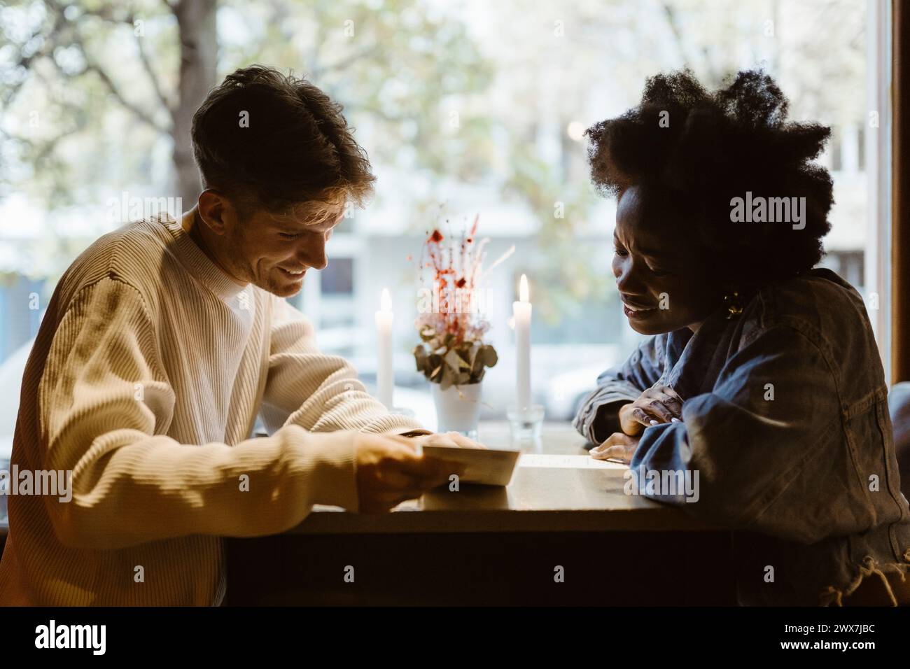 Freund und Freundin lesen Menükarte, während sie an der Bar sitzen Stockfoto