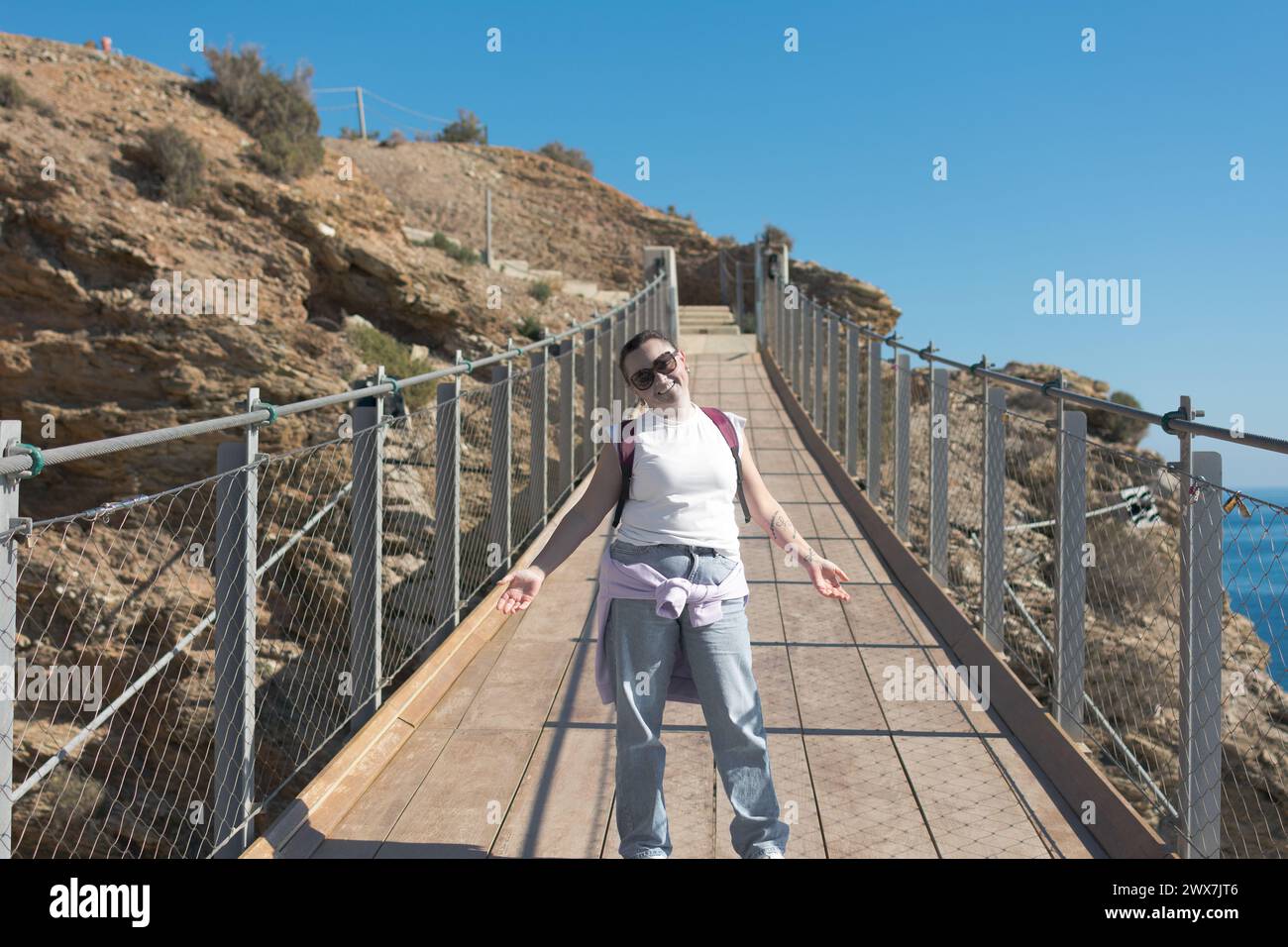 Erwachsene Frau posiert auf der Hängebrücke Stockfoto