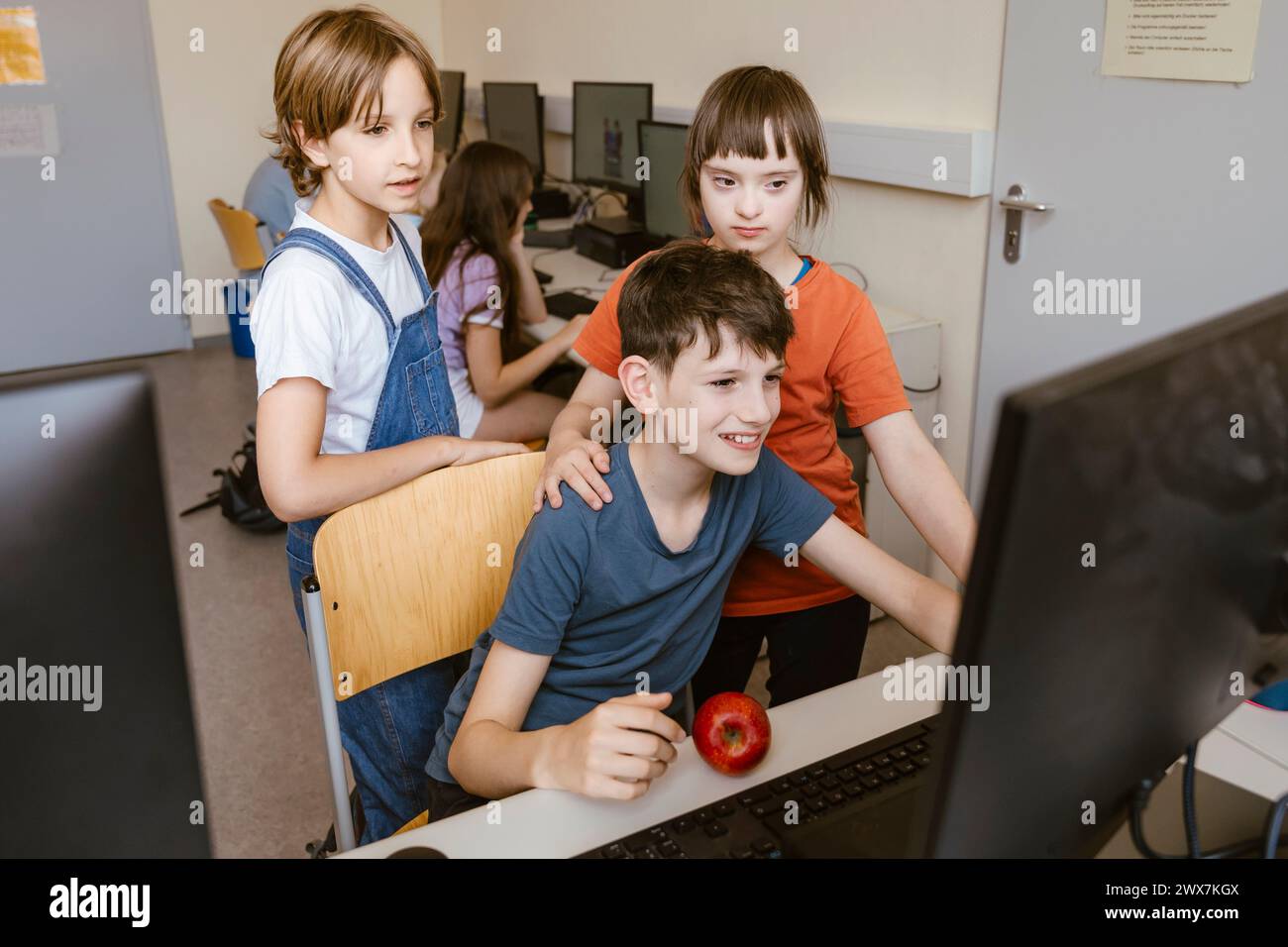 Schülerinnen und Schüler mit Down-Syndrom-Mädchen am Schreibtisch im Klassenzimmer Stockfoto