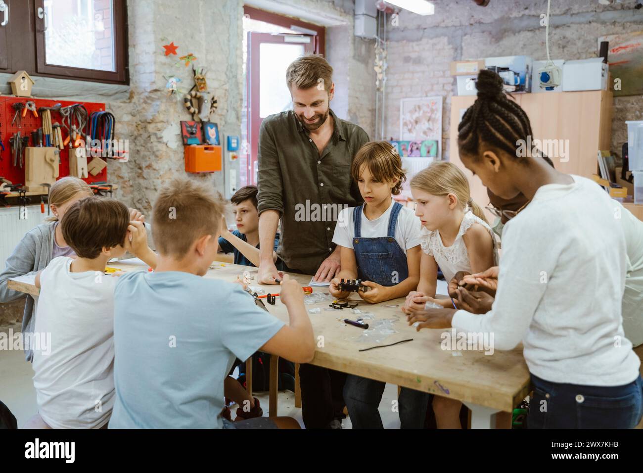 Lehrerin mit Gruppe von Schülern, die an Robotik-Projekt in der Technikwerkstatt in der Schule arbeiten Stockfoto