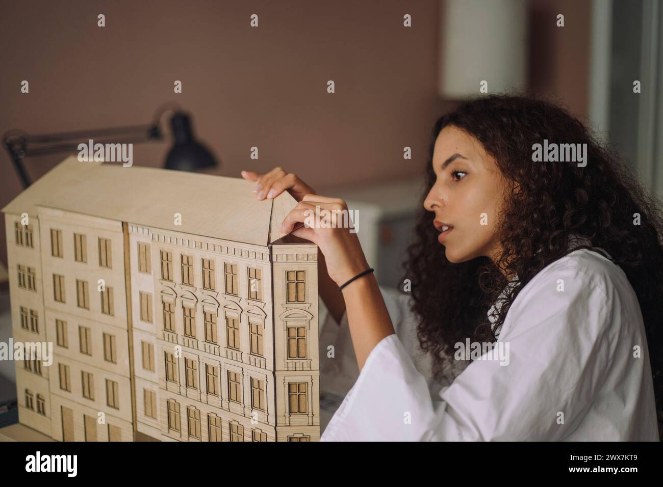 Fokussierte weibliche Designerin, die das Baumodell während der Arbeit im Büro vorbereitet Stockfoto