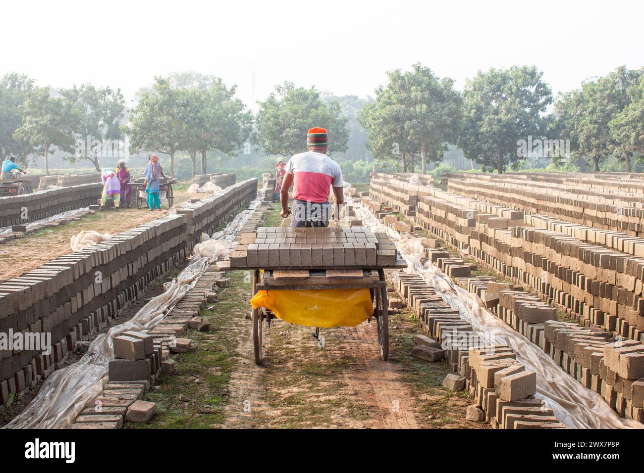 Ein Arbeiter trägt Ziegelsteine bei Maurer in Khulna, Bangladesch. Stockfoto