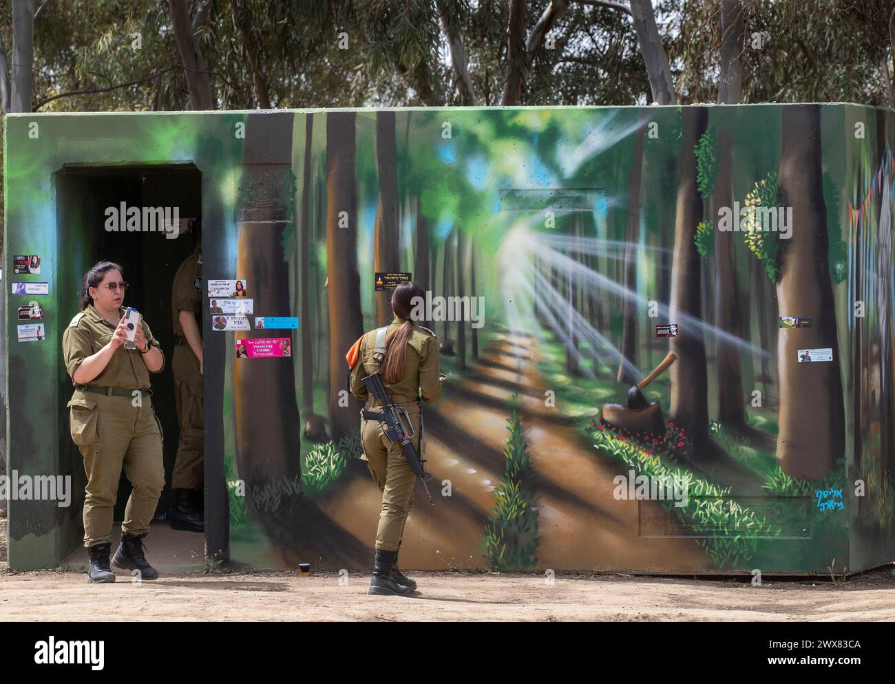 Israelische Soldaten im „Bombenschutzraum“ platzierten und malten am 28. März 2024 wie die umliegenden Wälder in der Gedenkstätte in Re'im, Süd-Israel. Am 7. Oktober 2023 wurden Hunderte Israelis, die hier eine Tanzparty besuchten, von Hamas-Terroristen massakriert, die aus dem Gazastreifen infiltrierten und an Dutzenden von Orten etwa 1.200 Israelis töteten. Es gibt viele Berichte über Vergewaltigungen, die die Hamas während des Tanzfestes während ihres Tötungsauftritts verübt hat. Foto von Jim Hollander/UPI Credit: UPI/Alamy Live News Stockfoto