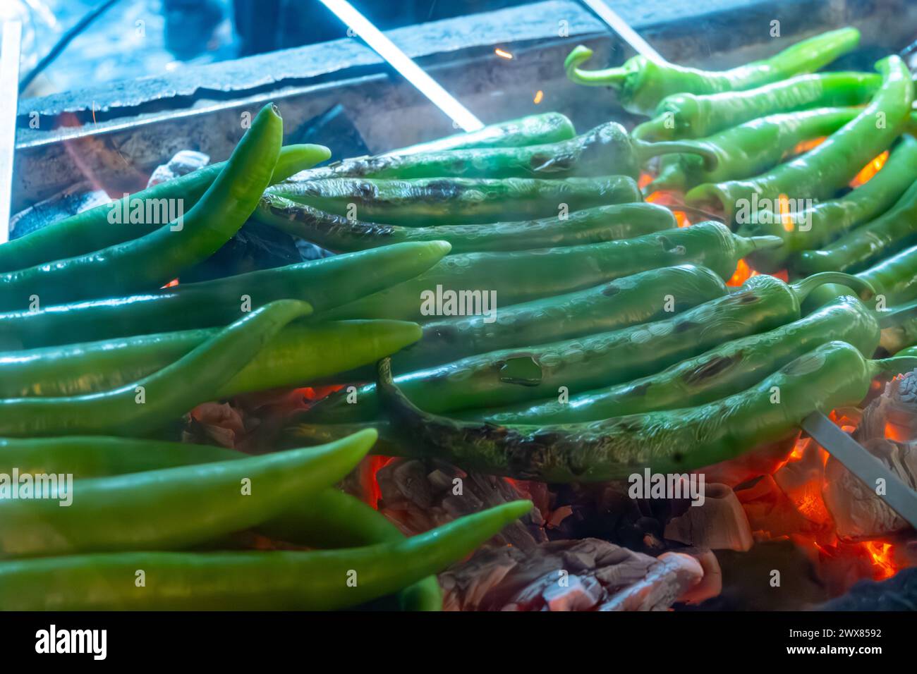 Barbecue mit grüner türkischer Paprika auf geflammtem Holzkohlegrill im türkischen Restaurant Stockfoto