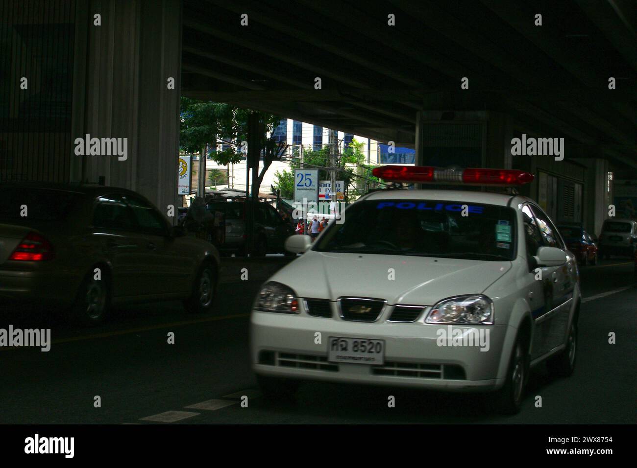 Bangkok, Thailand - 11. Juli 2005: Thailändischer Polizeiwagen, der unter einer Brücke in Bangkok vorbeifährt. Stockfoto