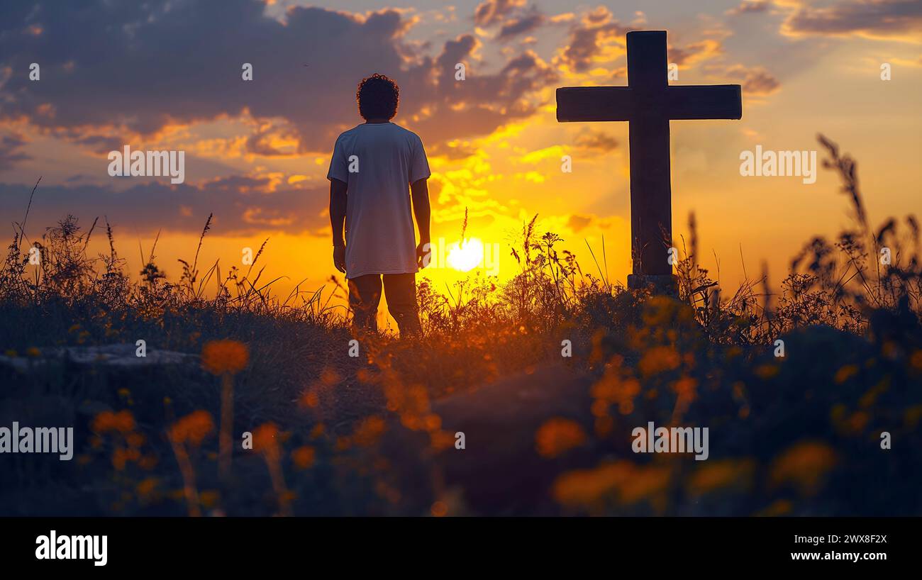 Mann vor dem alten Holzkreuz bei Sonnenuntergang. Christentum- und Gottesbegriff. Stockfoto
