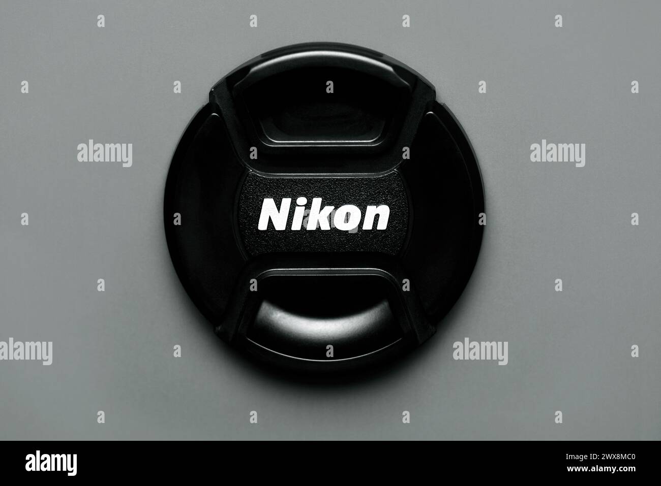 Nahaufnahme der Objektivkappe der Nikon Kamera auf grauem Hintergrund. Illustrativer Leitartikel Stockfoto