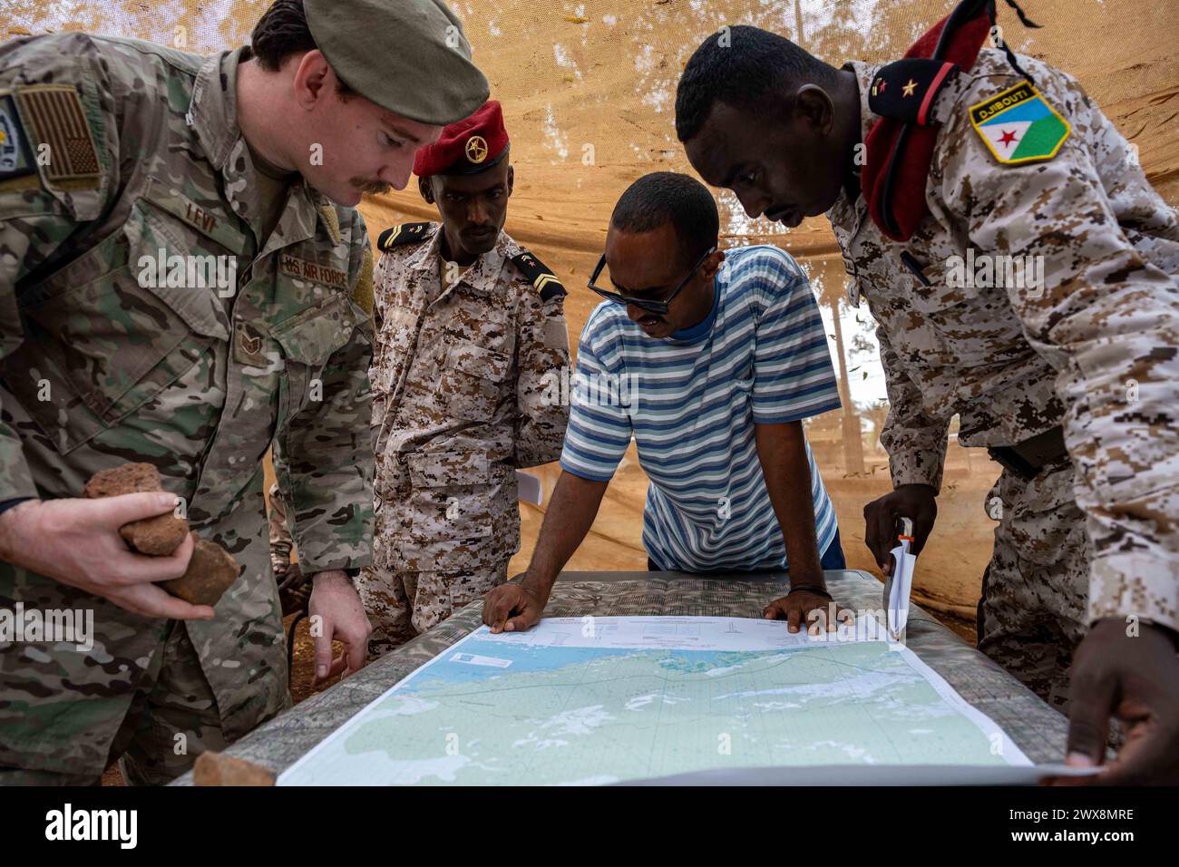 Ali Ouney, Dschibuti. März 2024. Zach Levi, untergeordneter Offizier des Joint Personnel Recovery Center Survival, Evasion, Resistance and Fluchtoperationen, überprüft eine Karte mit Mitgliedern des Armed Forces of Djibouti Rapid Intervention Bataillons (Batallion d'Intervention rapide, BIR 21. März 2024 in Ali Ouney, Dschibuti). Die bilaterale Ausbildung diente dazu, die dauerhafte Partnerschaft zwischen den US-amerikanischen und dschibutischen Truppen zu stärken, um transnationalen Bedrohungen entgegenzuwirken und regionale Sicherheit, Stabilität und Wohlstand zu fördern. (Foto: Allison Payne) (Credit im Stockfoto