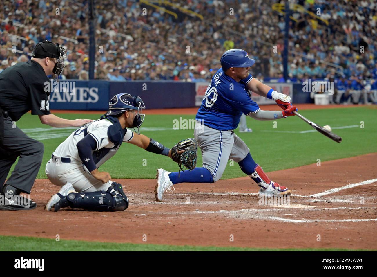 St. Petersburg, Usa. März 2024. Der Titelverteidiger Todd Tichenor (13) und der Tampa Bay Rays Catcher Rene Pinto (C) beobachten, wie der Toronto Blue Jays Catcher Alejandro Kirk (30) eine RBI-Single von Zach Eflin während des sechsten Inning eines Baseballspiels im Tropicana Field in St. trifft Petersburg, Florida am Donnerstag, 28. März 2024. Foto: Steve Nesius/UPI Credit: UPI/Alamy Live News Stockfoto