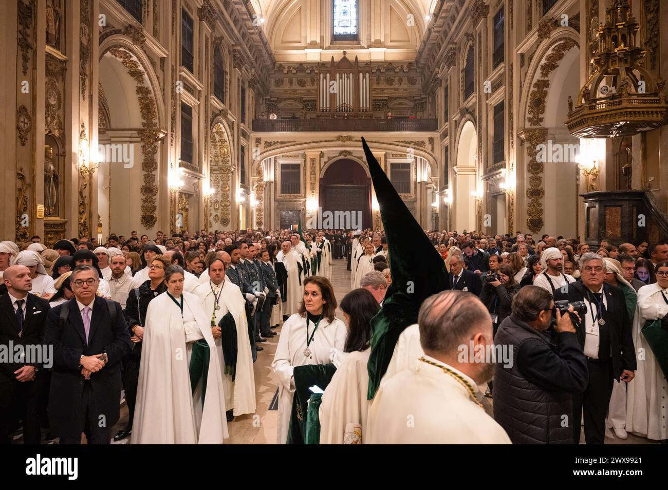 Madrid, Spanien. März 2024. Im Inneren der Kirche San Isidro, auch bekannt als Stiftskirche San Isidore, zeigt die Bruderschaft Gran Poder und Priester, die am Heiligen Donnerstag eine Messe veranstalten, als die Prozession unterbrochen wurde. Madrid erlebte ungünstige Wetterbedingungen, darunter Regen und Wind, was die Absage der Osterprozessionen am Donnerstag zwang. Diese Entscheidung wurde getroffen, um Verletzungen von Pönitenten durch rutschige Böden zu verhindern und die unbezahlbare Geschichte und das Erbe der Bruderschaften zu bewahren. Quelle: SOPA Images Limited/Alamy Live News Stockfoto