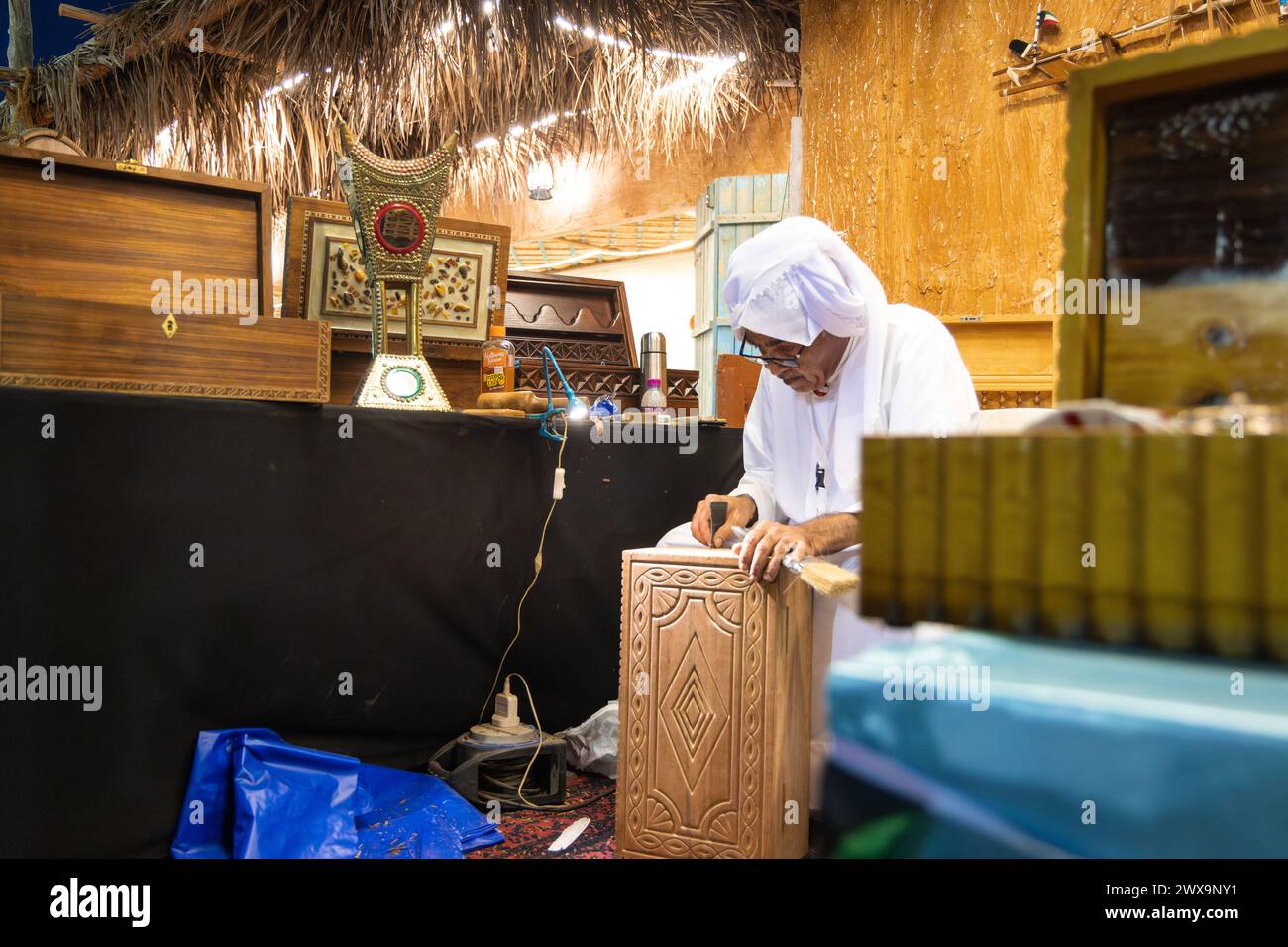 Ein arabischer Katar schnitzt Holz. Traditionelles arabisches Kunsthandwerk. Stockfoto