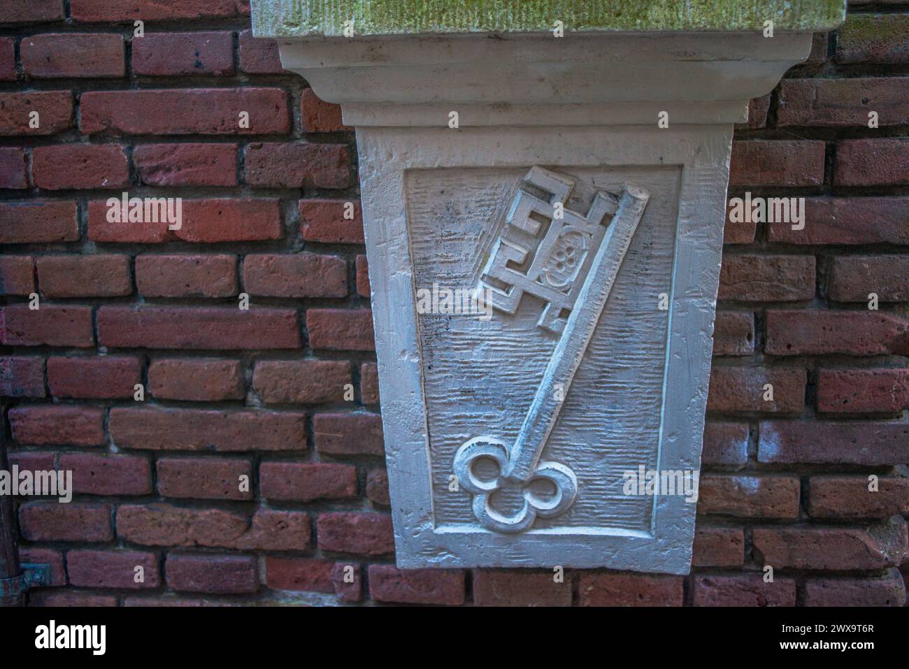 Eine innovative, schlüsselförmige Skulptur ziert eine Amsterdamer Straßenmauer und verbindet künstlerischen Ausdruck mit zeitgenössischem Design im Stadtbild. Stockfoto