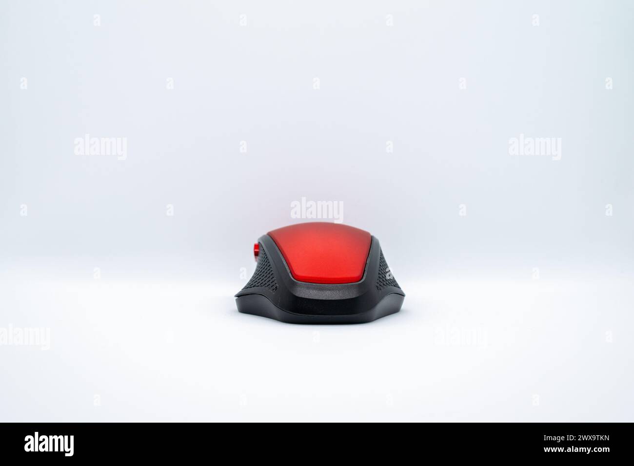 Eine elegante rote Maus auf einem sauberen weißen Hintergrund, die Stil mit Präzision für eine nahtlose Computernavigation kombiniert. Stockfoto