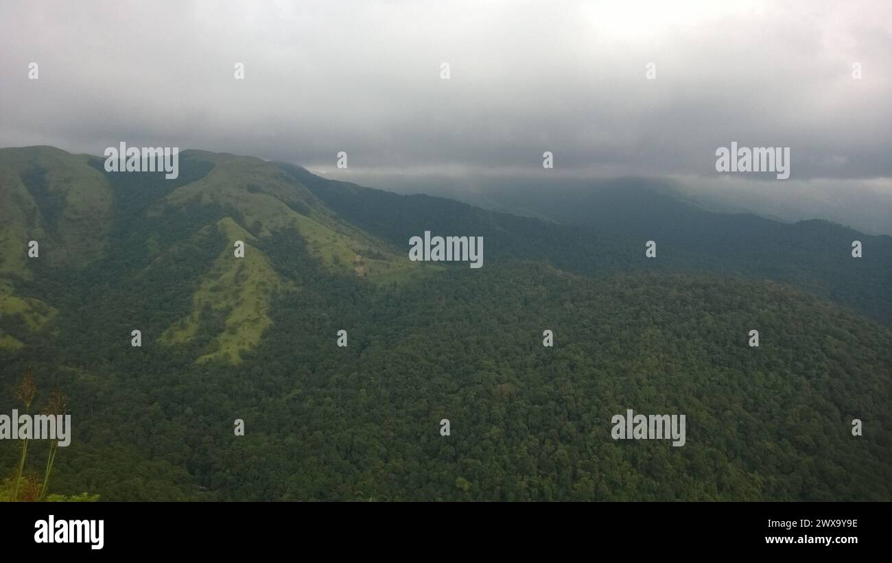 Die Monsun-Wolken umhüllen Charmady Ghats in Karnataka, Indien, mit üppigen tropischen Wäldern und Hügeln Stockfoto