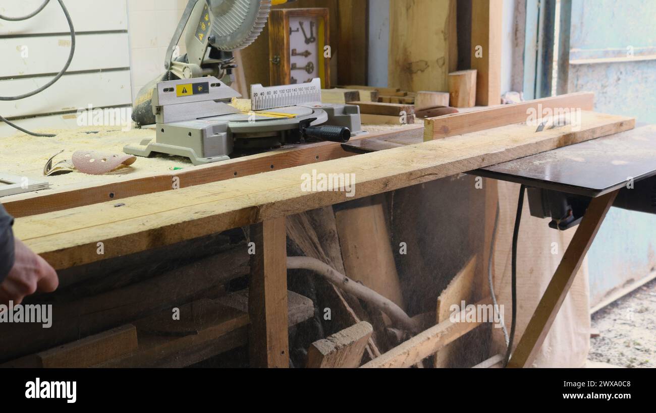 Hausgemachte Kreissäge in Form eines Klapptisches mit einer scharfen Scheibe zum Sägen von Holzmaterial in einer Tischlerei, Schneiden eines breiten Brettes Stockfoto