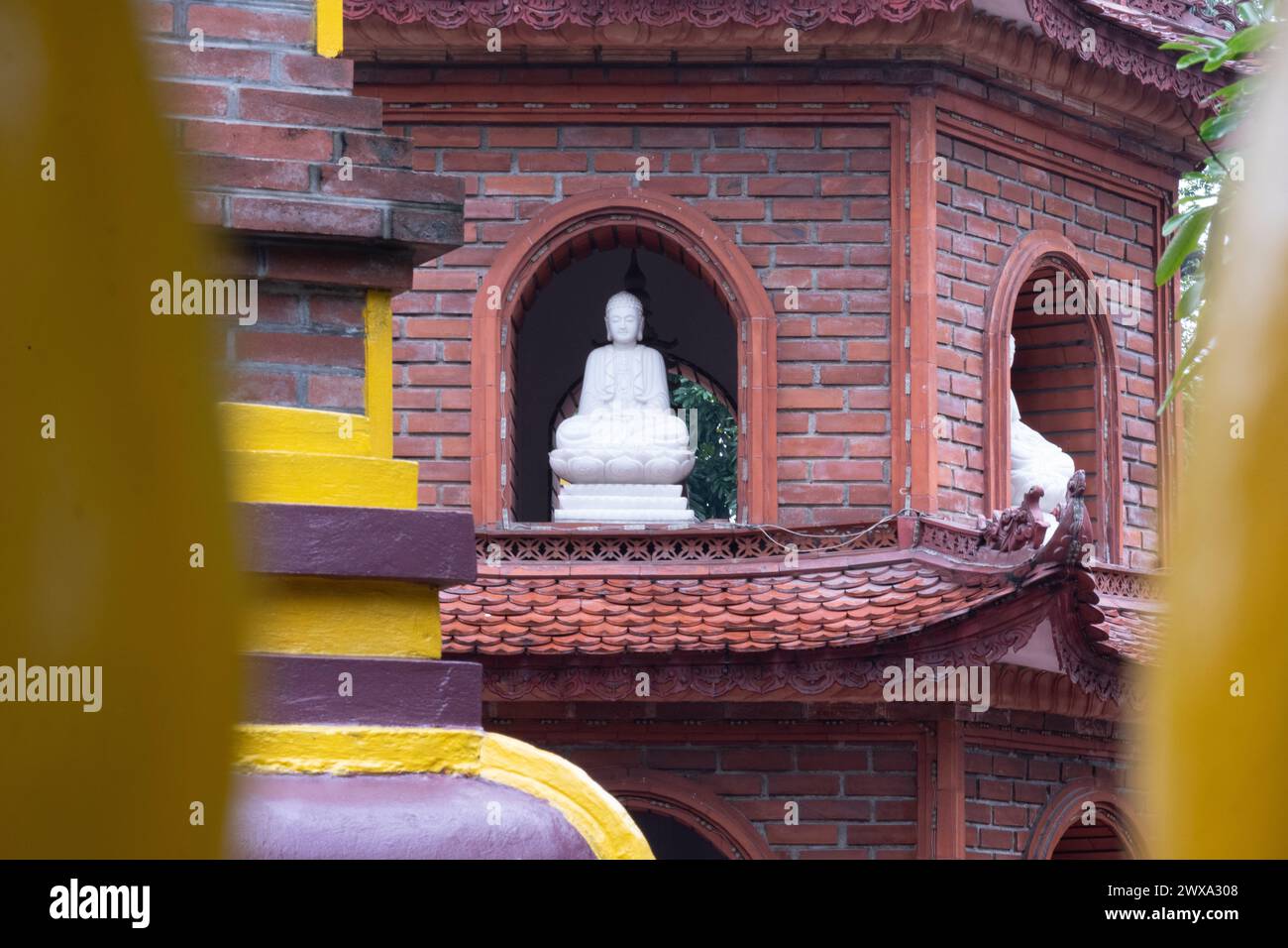 Buddha-Statue. Weiße Statue. Tran Quoc Pagode im Hintergrund, Hanoi, Vietnam Stockfoto