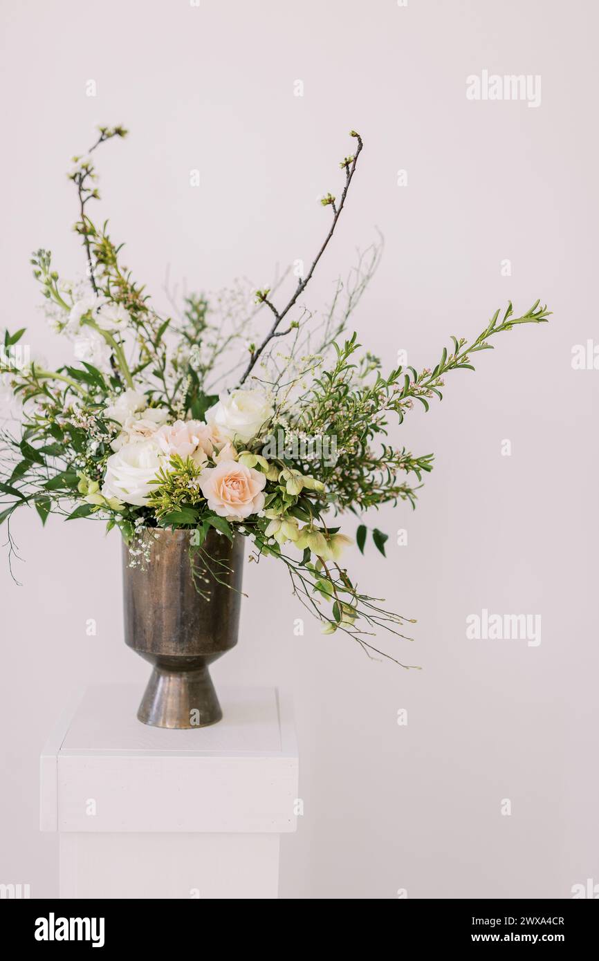 Elegantes Blumenarrangement in moderner Vase auf Sockel Stockfoto