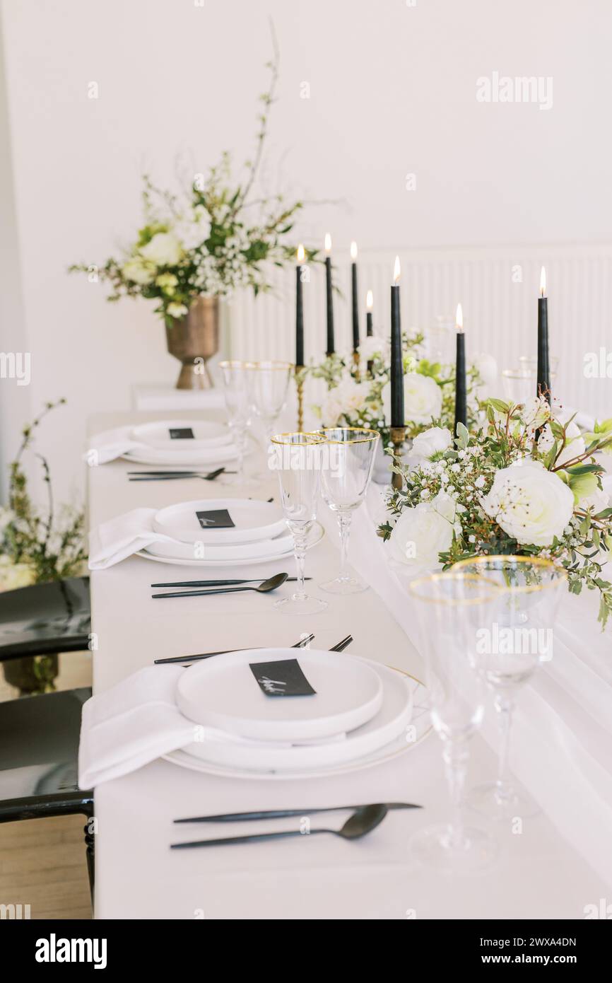 Schicker Hochzeitstisch mit floraler Eleganz und Kerzenlicht Stockfoto