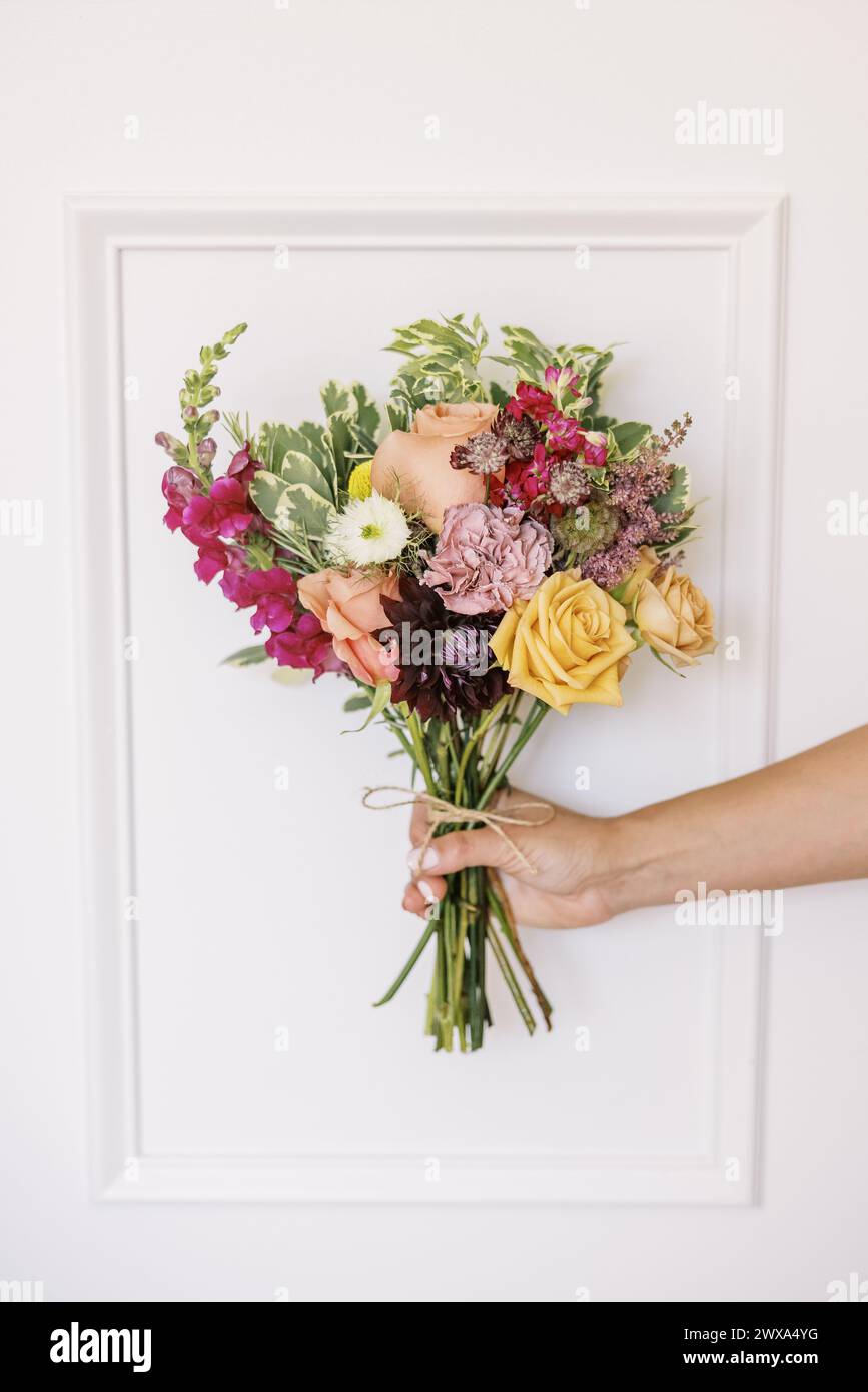 Lebendiger Blumenstrauß in der Hand, in weiß gerahmt Stockfoto