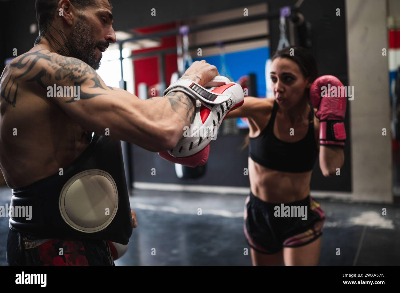 Boxersparring mit Personal Trainer im Fitnessstudio Stockfoto