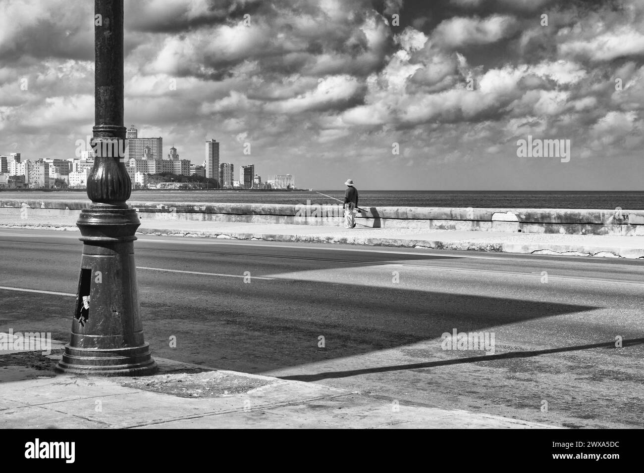 Ein einsamer Fischer auf dem Malecon. Es ist eine breite Esplanade, eine Straße Stockfoto