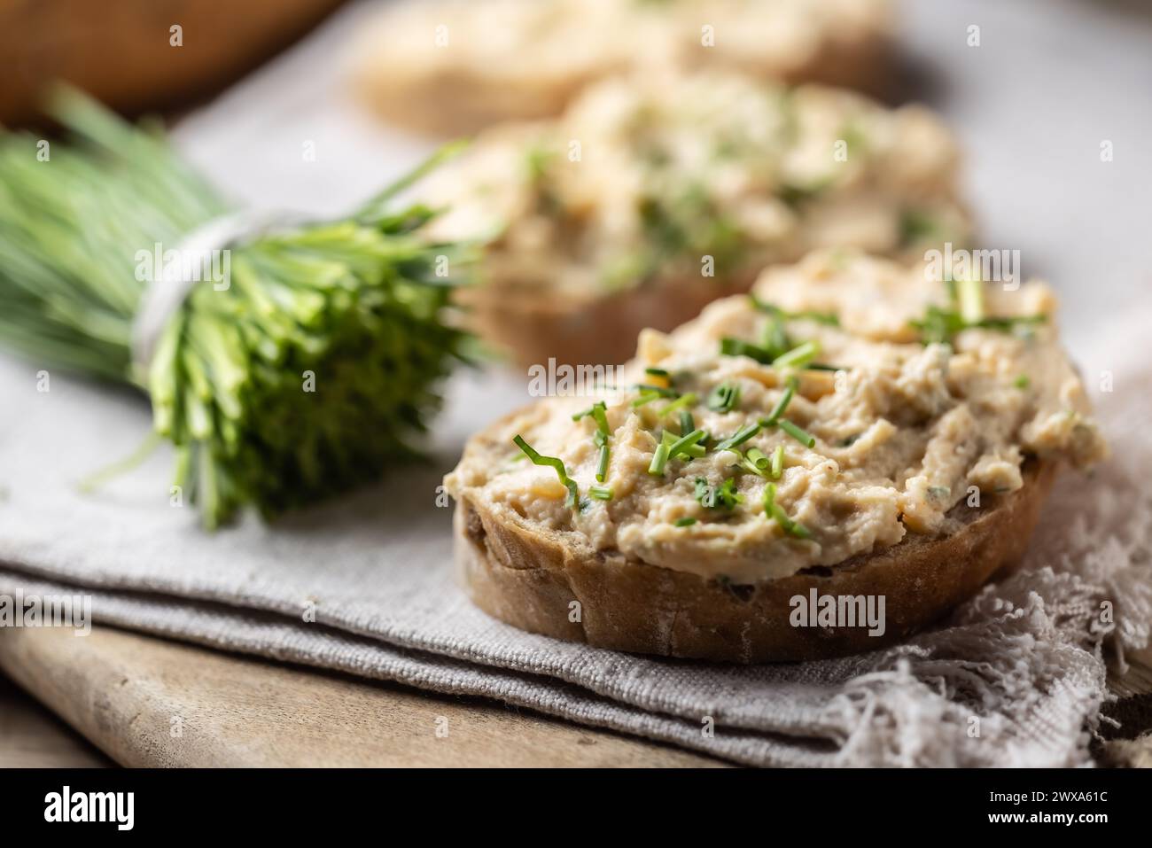 Bryndza mit rotem Pfeffer, Knoblauch und Schnittlauch. Brot mit Käseaufstrich. Stockfoto