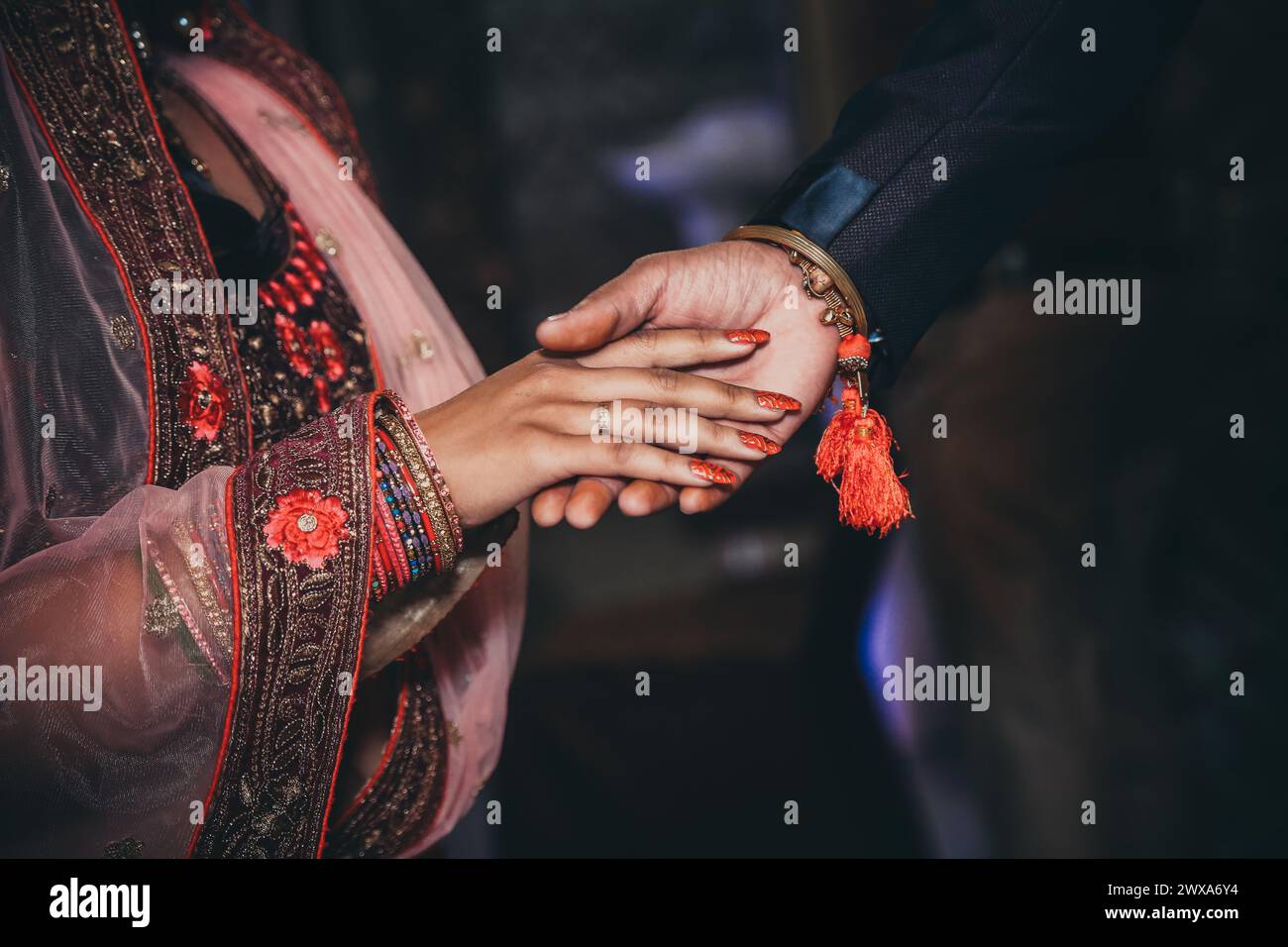 Eine Nahaufnahme eines indischen Paares, das bei der Hochzeitszeremonie die Hände hält Stockfoto