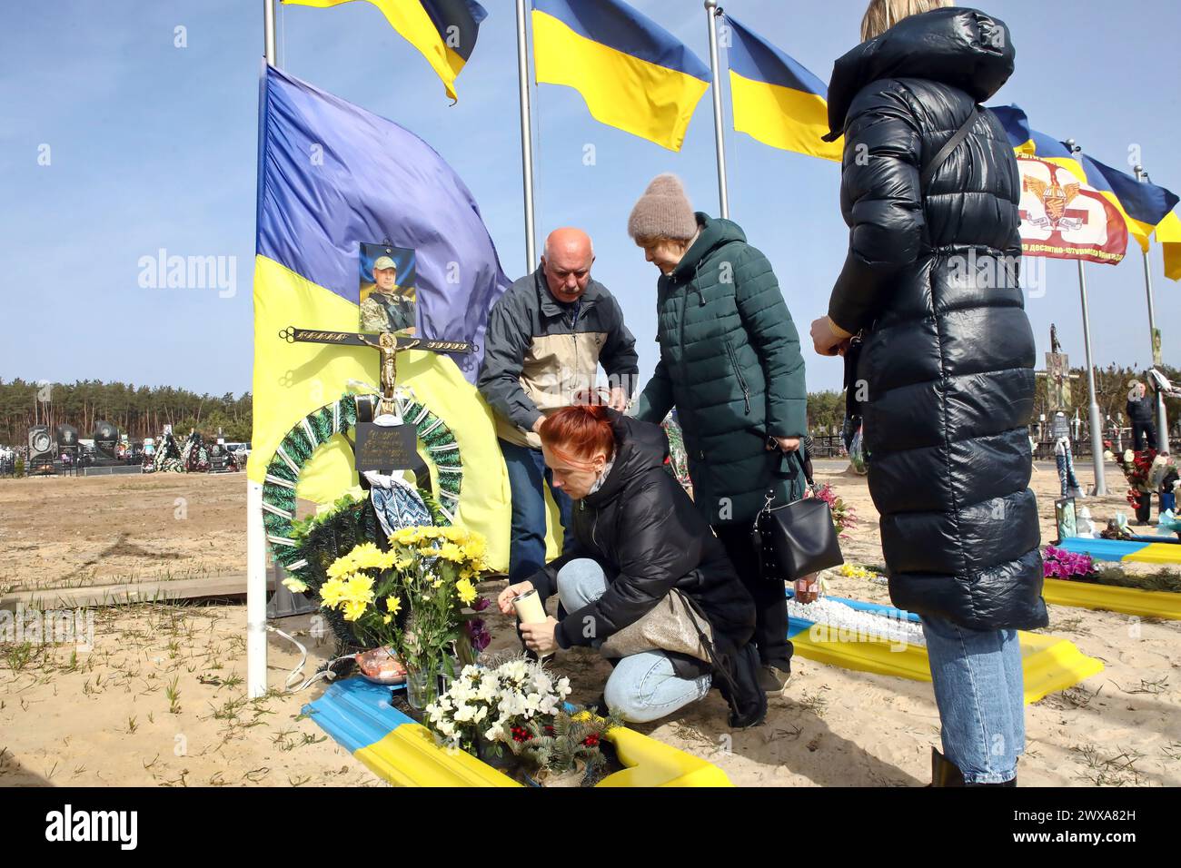 IRPIN, UKRAINE - 28. MÄRZ 2024 - am zweiten Jahrestag der Befreiung der Stadt von den russischen Eindringlingen, Irpin, Region Kiew, Nordukraine, wird das Grab eines verstorbenen Verteidigers der Ukraine auf dem Friedhof der Stadt Irpin gepflegt. Stockfoto