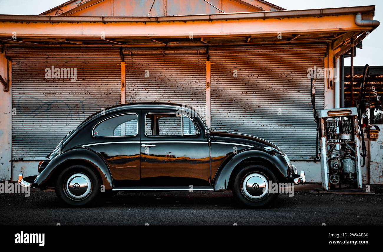 Klassischer VW VW Käfer Schwarz weiß vorne alte Tankstelle Garage Kraftstoffpumpe Bowser. Der „Black Bug“, hergestellt im Werk Clayton 1961 Stockfoto