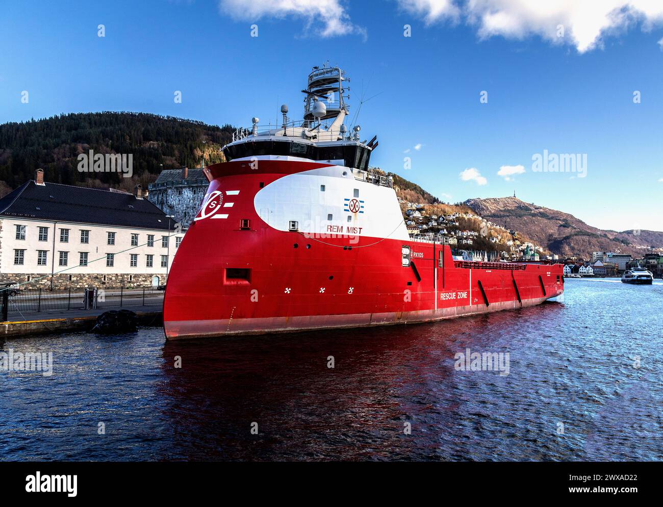 PSV-Offshore-Plattform-Versorgungsschiff Rem Mist legte in Festningskaien im Hafen von Bergen, Norwegen, an. Mount Ulriken im Hintergrund Stockfoto