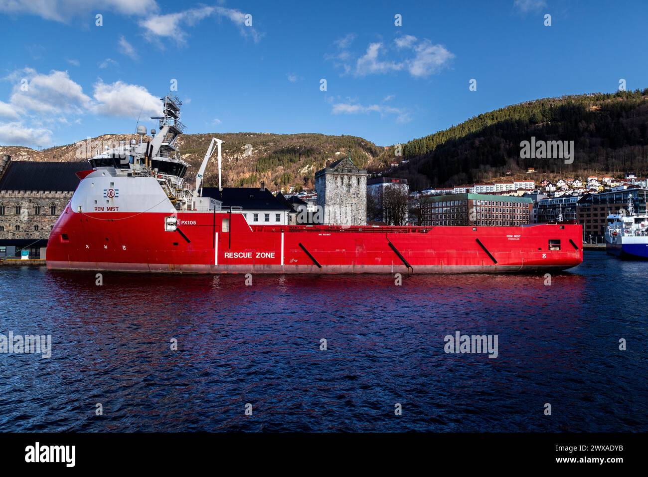 PSV-Offshore-Plattform-Versorgungsschiff Rem Mist legte in Festningskaien im Hafen von Bergen, Norwegen, an. Haakonshallen, Bergenhus und Rosenkrantzturm Stockfoto