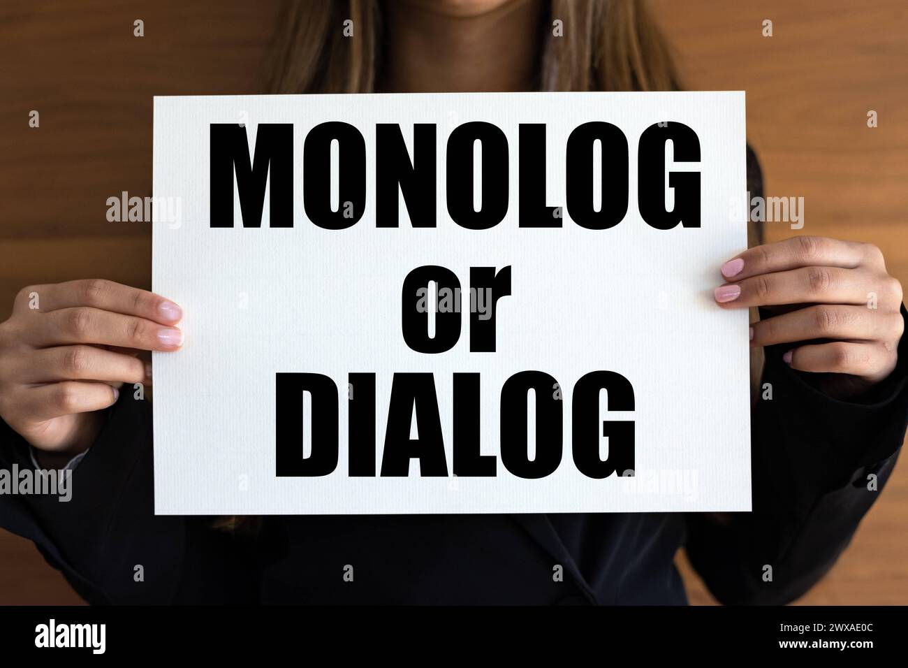 Monolog oder Dialog. Monolog oder Dialog. Frau mit weißer Seite, schwarzen Buchstaben. Kommunikationsform, Interview, Rede, Diskussion. Banner A1989 063 MON Stockfoto