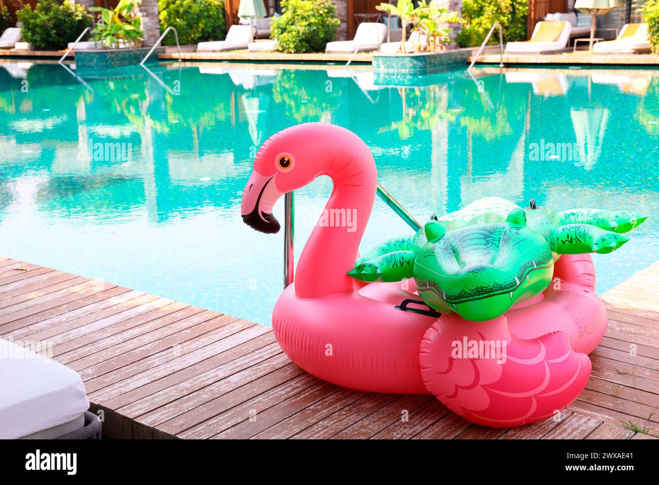 Schwimmt in Form von Krokodil und Flamingo auf Holzterrasse in der Nähe des Swimmingpools im Luxusresort Stockfoto