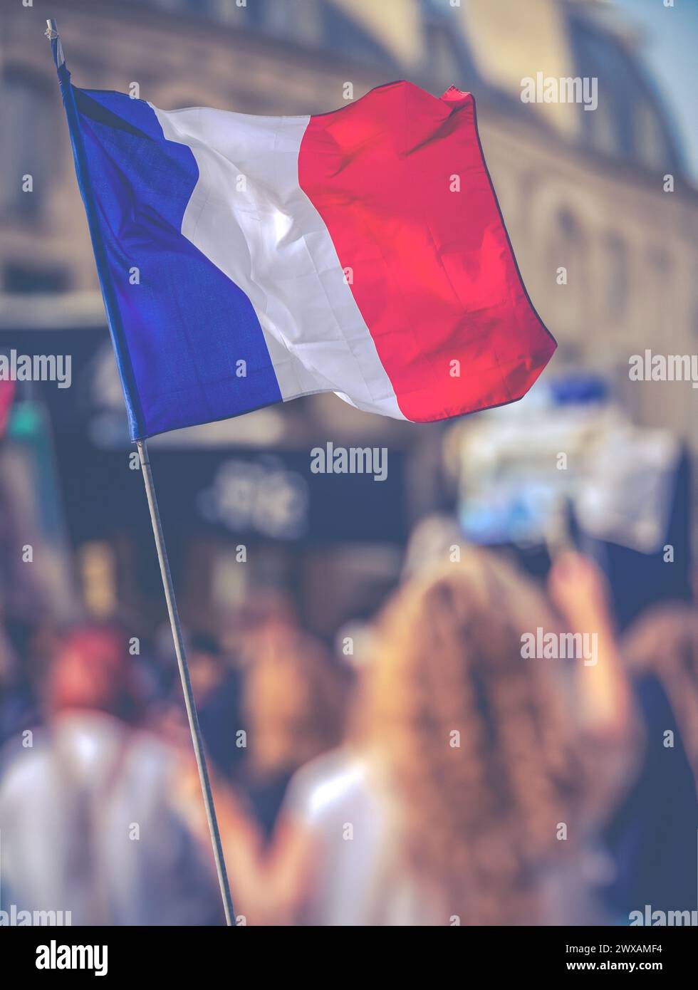 Ein Protest in Einer Pariser Straße mit Einer französischen Flagge im Vordergrund Stockfoto