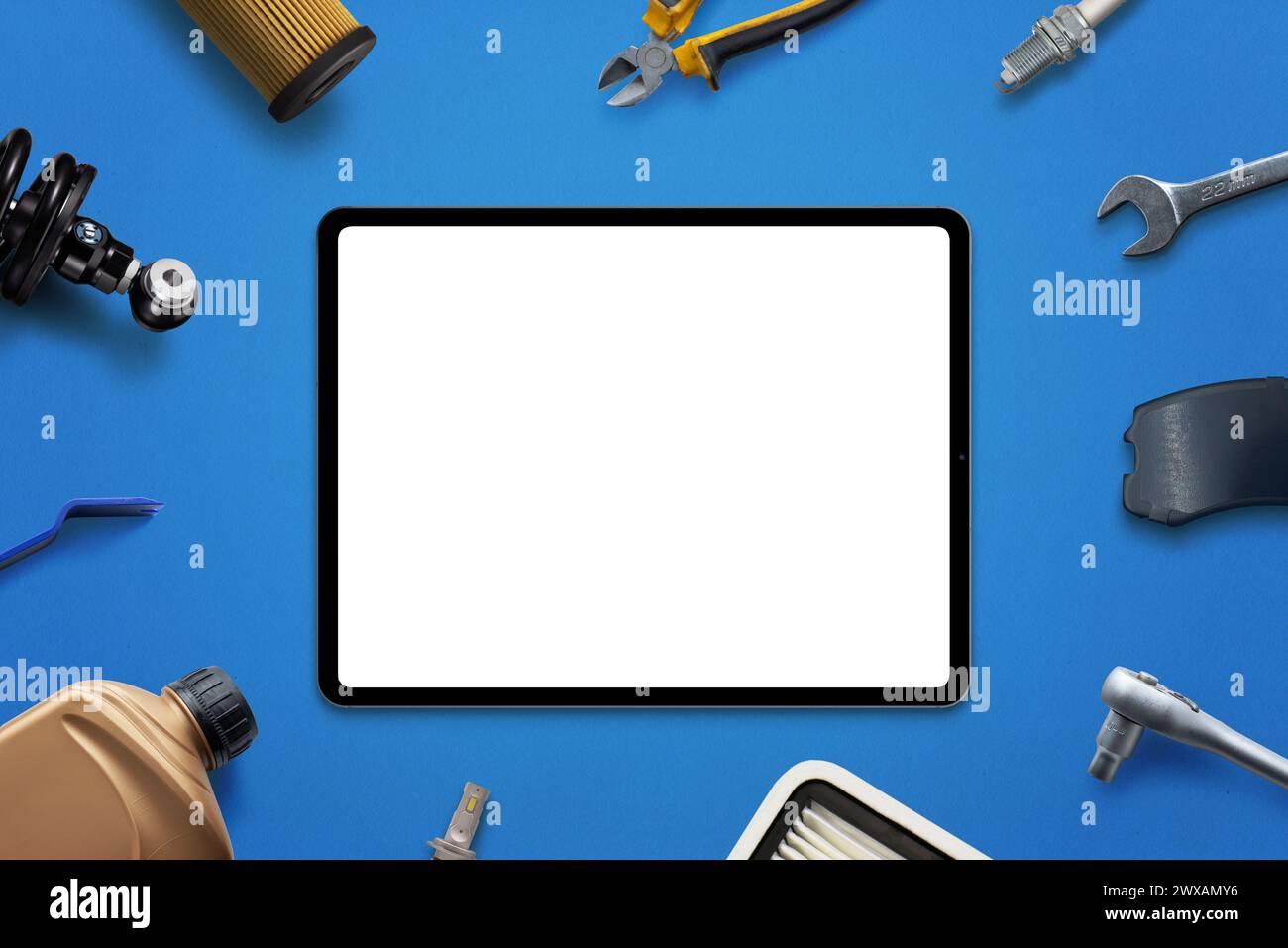 Tablet-Mockup mit isoliertem Bildschirm für App- oder Webseitenwerbung, umgeben von Autoteilen und Werkzeugen. Konzept des Fahrzeugservice oder des Teileverkaufs Stockfoto
