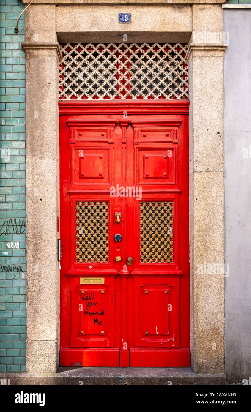 Nahaufnahme der leuchtend roten Türen an der historischen Fassade im Stadtteil Ribeira, Porto, Portugal Stockfoto