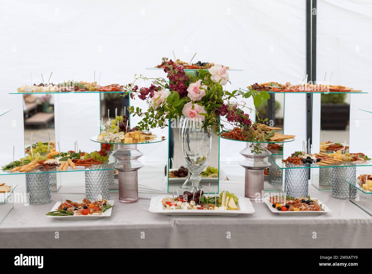 Ein Tisch, der mit einer Auswahl verschiedener Arten von Speisen bedeckt ist, von Obst und Gemüse bis hin zu Fleisch und Gebäck, was eine farbenfrohe und appetitliche Atmosphäre schafft Stockfoto