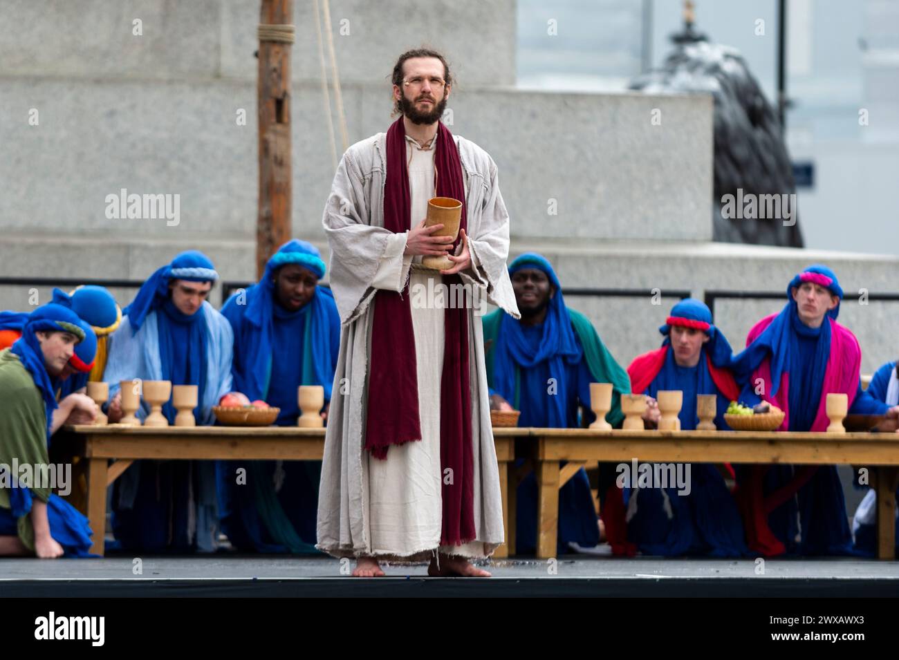 London, Großbritannien. 29. März 2024. Der Lehrer und ausgebildete Schauspieler Peter Bergin spielt Jesus mit seinen Jüngern beim Letzten Abendmahl, während die Wintershall-Spieler „die Passion Jesu“ aufführen, die an den Tag erinnert, an dem Jesus Christus von den Römern verhaftet, vor Gericht gestellt und gekreuzigt wurde, bevor er am Ostersonntag von den Toten auferstanden war. Eine Besetzung von mehr als 100 Schauspielern und Freiwilligen sowie Pferden, Eseln und Tauben erwecken die Geschichte am Trafalgar Square zum Leben. Quelle: Stephen Chung / Alamy Live News Stockfoto